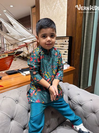 Another shot of our client looking stylish in the green and blue printed kurta set, comfortably seated in our store.