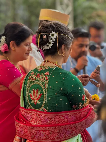 A candid shot from the wedding ceremony, showing the beautiful bridal bun from the back.