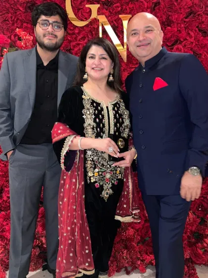 Crafting bespoke garments for the entire family is a privilege. Here, clients are dressed in custom-made formal wear, including a classic navy Bandhgala jacket with a red pocket square and a sharp grey suit, showcasing tailored elegance for any celebration.