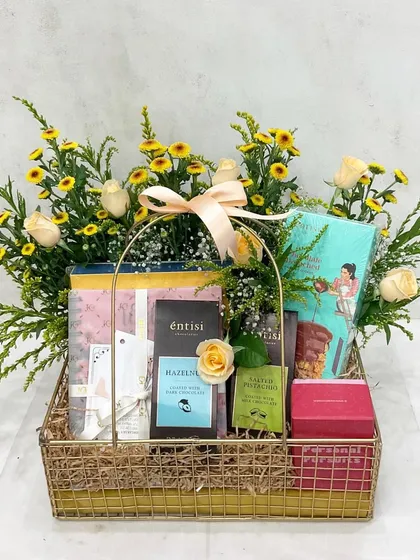 The perfect gift for a newly engaged couple. This floral basket includes a 'Personal Pursuits' game, a bridal planner, and gourmet chocolates to celebrate their journey ahead.