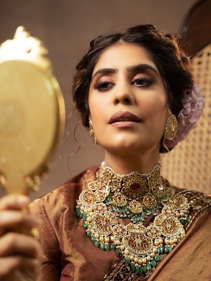 A close-up shot focusing on the magnificent bridal jewelry. The image highlights the craftsmanship of the multi-layered necklace and the model's traditional makeup, perfect for a high-end jewelry campaign.