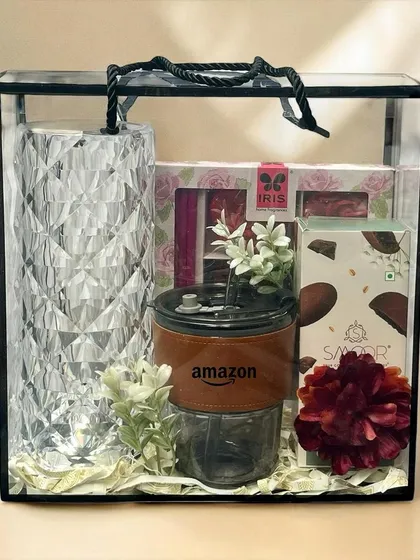 An elegant corporate gift for Amazon, presented in a clear acrylic box. The hamper includes a branded tumbler, a crystal-cut lamp, and other premium items.