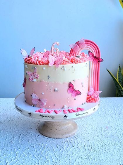 A full view of the pink butterfly and rainbow cake. The monochromatic color scheme gives it a unique and elegant look.