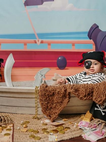 A baby pirate with an eye patch, surrounded by skulls and gold coins.