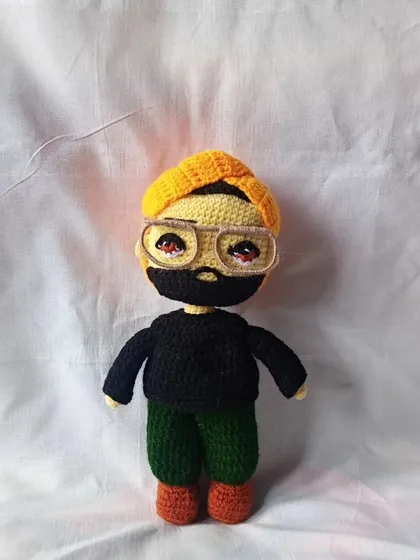 This is a custom-made doll of a man with a beard and a yellow beanie, created from a customer's picture. I focus on these small details to make each doll special.
