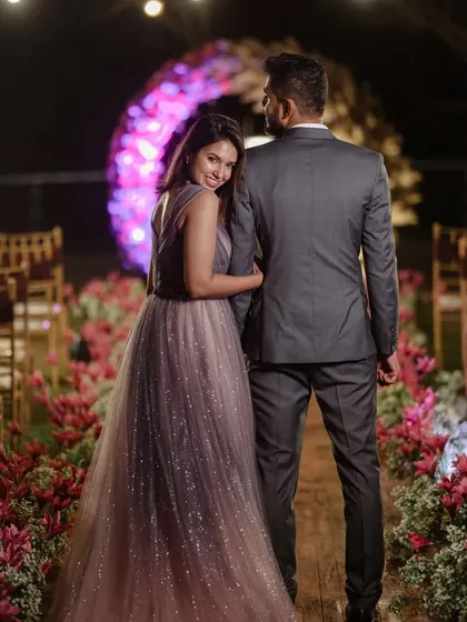 A romantic portrait of the couple in their beautifully decorated aisle. The pink floral arrangements and warm lighting create an enchanting atmosphere for their engagement photos.