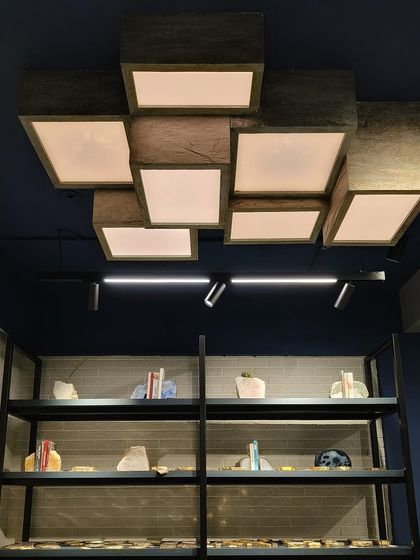 A closer look at the custom-made stone veneer backlit light fixture. This piece is not just a source of light but a sculptural element that elevates the design of the entire retail space.