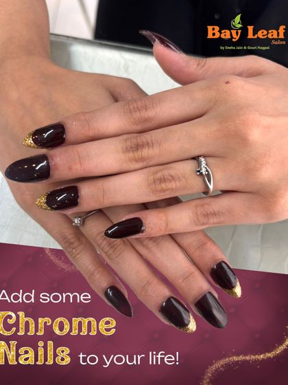 Dark, dramatic, and glamorous. This look features long, almond-shaped nails in a deep, glossy black with a touch of gold chrome at the cuticles for a sophisticated finish.