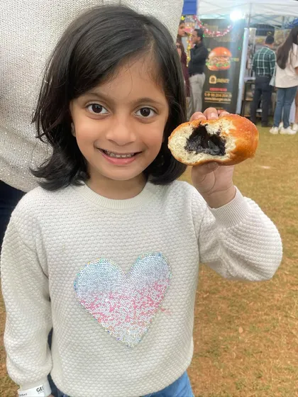 A happy smile and a half-eaten chocolate stuffed donut. This is what pure joy looks like at one of my pop-up stalls.