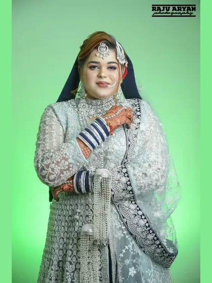 A confident and poised bridal portrait. Her arms crossed, she looks directly at the camera with a gentle smile, radiating grace on her wedding day.