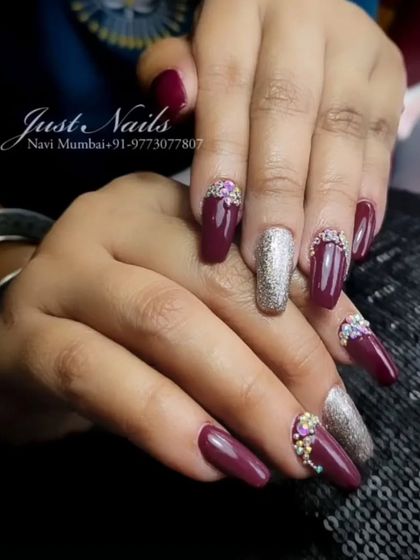 A luxurious-looking set with a deep plum base, a silver glitter accent nail, and intricate rhinestone work at the cuticles.