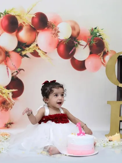 A classic first birthday portrait setup, featuring a beautiful balloon arch and a little girl ready to celebrate. This shows the elegant and styled side of my birthday sessions, captured before the cake smash fun begins.