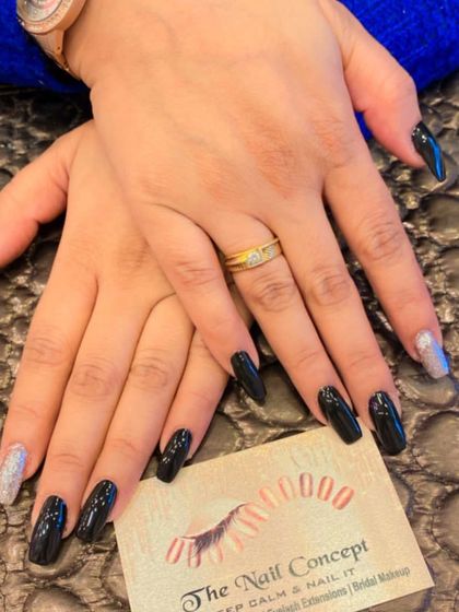 A chic and modern set of long, black coffin nails. The design is elevated with two silver glitter accent nails for a striking contrast.