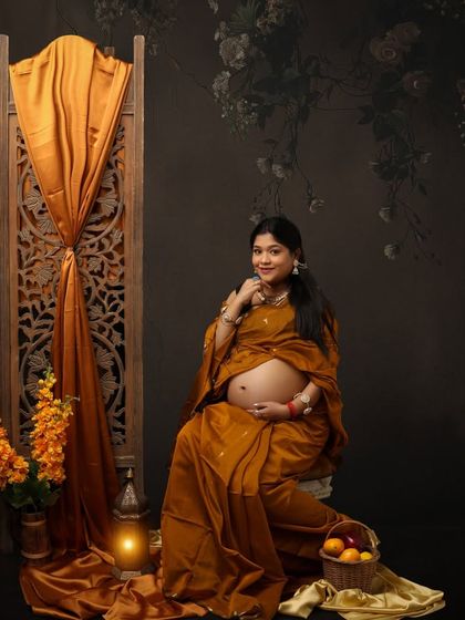 Embracing motherhood, draped in timeless tradition. This portrait in a mustard-colored saree has a beautiful, earthy, and rustic feel.