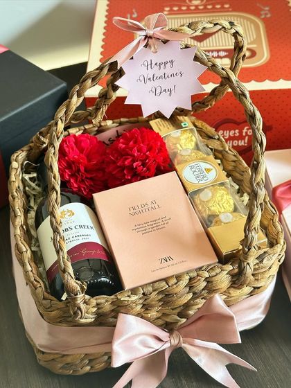 Our "Basket of Love" is the perfect Valentine's Day gesture. This wicker basket is filled with red wine, a Zara perfume, a face sheet mask, and Ferrero Rocher, all tied with a pink ribbon.