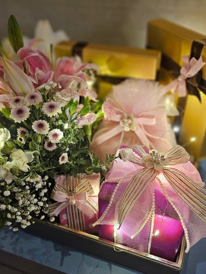 This pretty pink trousseau is packed with a touch of shimmer and layered with shell tassels. The warm glow of fairy lights woven through the fresh florals adds a truly magical feel to the arrangement.