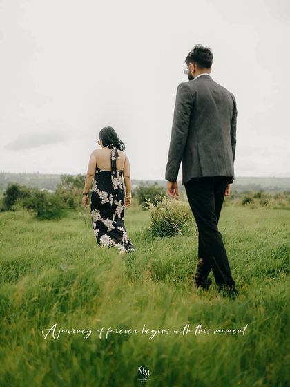 A journey of forever begins with this moment. The couple walks through a lush green field, symbolizing their path forward together.