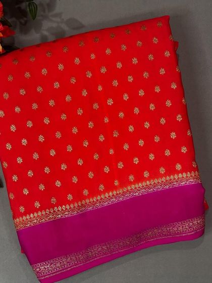 A flat lay of the vibrant red Bentex Banaras saree with a rani pink border.