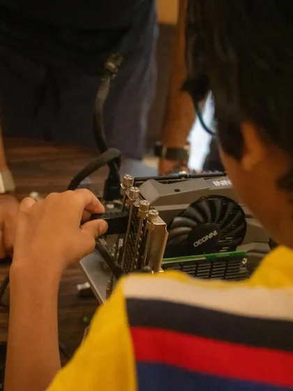 A student carefully plugs a cable into the graphics card. Learning the function of each component is the first step before we start the hands-on assembly.