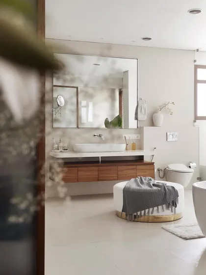 A view of the all-white transformed bath in 'A Walk in the Clouds', featuring a freestanding tub and integrated wardrobe.