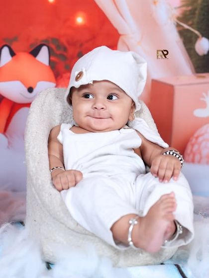 A close-up of the baby in the winter woodland scene, smiling sweetly. This shot captures the innocent joy of a child in a magical, imaginary world.