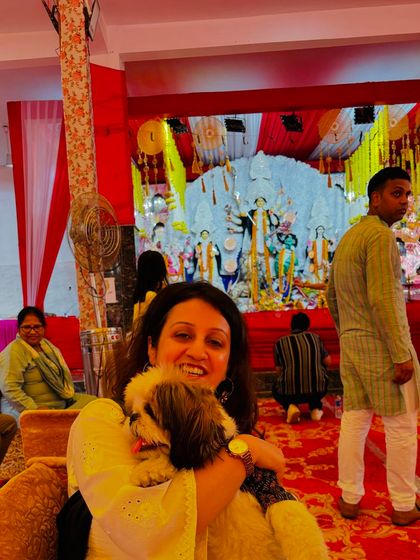 A smiling pet parent cuddles her Shih Tzu while sitting at the event. These are the heartwarming moments of connection that our pet-friendly festivals are all about.