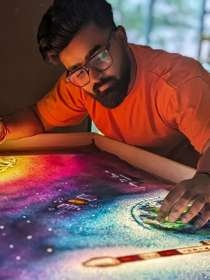 A close-up of me working on the Aditya L1 sand art, using colored sand to create the galaxy.