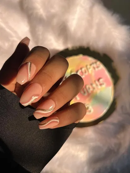 A soft and elegant look. These coffin-shaped extensions feature a nude base with delicate, hand-painted white and silver lines for a sophisticated and modern design.