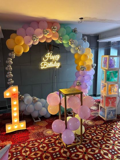 Another angle of the pastel rainbow first birthday, showing the custom 'AARYA' light-up blocks.