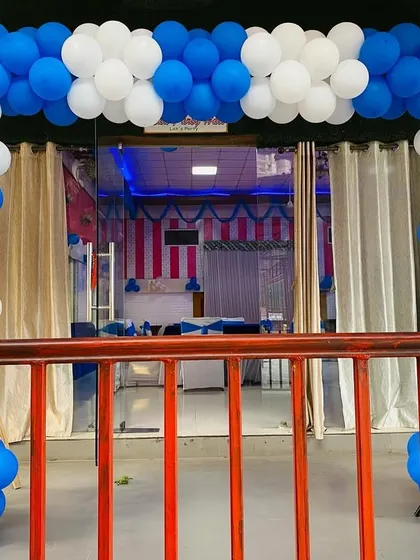 A blue and white balloon arch at the entrance of a venue, suitable for corporate events or large parties.