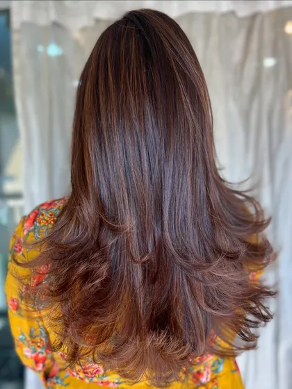 A full back view of these caramel layers. The haircut is designed to enhance the colour, with layers that allow the different tones to peek through.