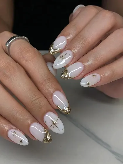 Celestial and chic. These milky white almond nails are adorned with 3D gold chrome and delicate gold star decals.