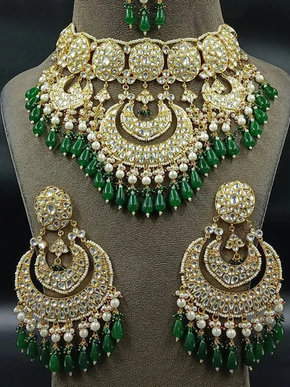 A stunning Pakistani-style bridal choker with large chandbali earrings. The intricate design with green beads and pearls makes this a standout rental piece.