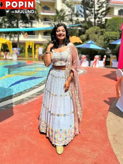 A full-length shot of the client in the light blue lehenga, smiling brightly. It’s a perfect example of a happy customer in a beautiful rental outfit.