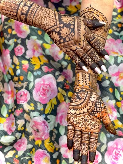 A close-up showing the details of the bridal mehendi, with a focus on the fingers and the back of the hand.