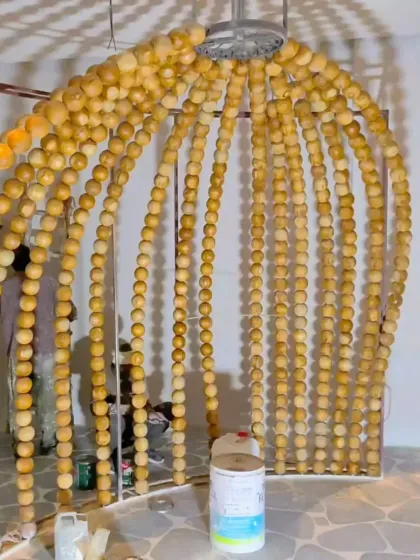 A still from the installation of the beaded dome, showing the craftsmanship involved in creating this unique feature. The wooden beads add a warm, natural texture to the entrance experience.