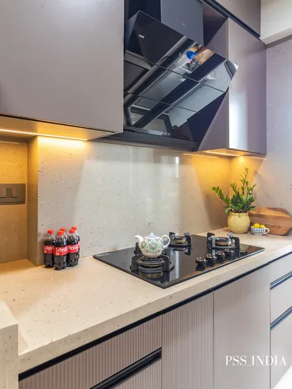 A close-up of the cooktop area in the galley kitchen. Under-cabinet lighting illuminates the workspace, and a few simple decorative items add a touch of style without creating clutter.