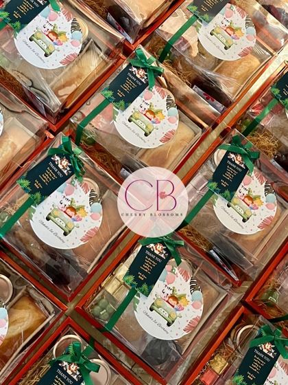 A large order of our jungle-themed confectionery return favours, all packed and ready to go. Each box includes a tea cake, cookies, assorted chocolates, and a mini bubble candle.