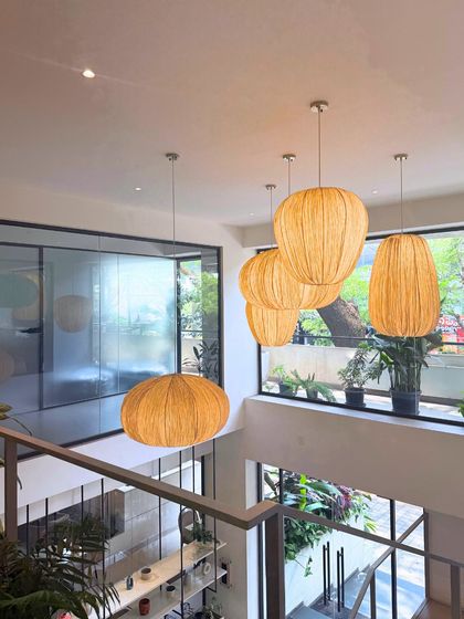 The view from the mezzanine at our Indiranagar cafe, highlighting the double-height ceiling, natural light, and our signature woven pendant lights.