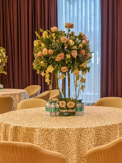 Elegant table settings for a banquet-style celebration. Tall floral centerpieces and classic round tables create a sophisticated environment for guests to dine and celebrate.