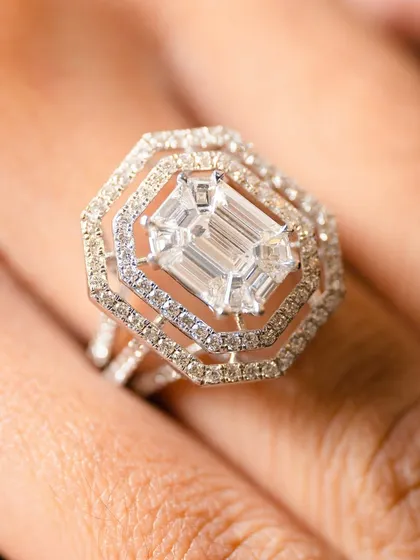 The architectural beauty of an emerald-cut diamond is simply captivating. This ring is designed for the woman who appreciates clean lines and a sophisticated, commanding sparkle. The tiered halo of smaller diamonds enhances its magnificent clarity and presence.