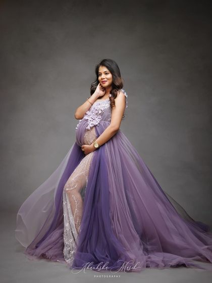 A vision in lavender. This flowing gown with floral appliqué and a sheer lace legging offers a unique blend of romance and modern style, perfect for a memorable maternity portrait.