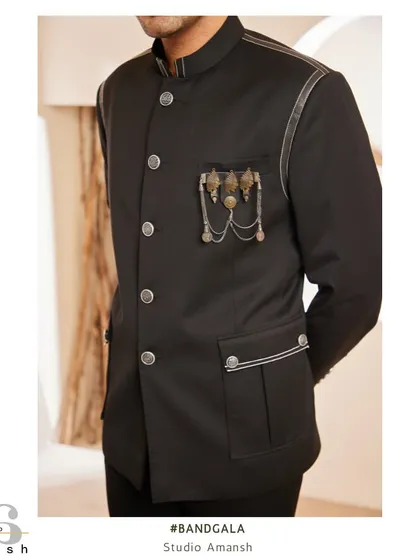 This image provides a clear view of the side profile and detailing on our black bandhgala jacket. The metallic brooch and subtle leather trim on the pockets and shoulders add a layer of modern luxury.