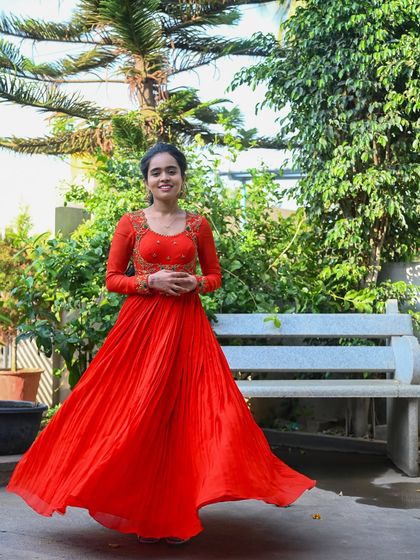 My enchanting client Nisarga looks stunning in this vibrant orange gown. I designed it with a flowing pleated skirt and an intricately embroidered bodice, creating a look of timeless elegance for her special event.