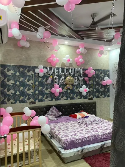 Another angle of a full bedroom welcome home decoration. You can see the "Welcome Baby" balloons, decorated crib, and balloon clusters filling the room with festive cheer.