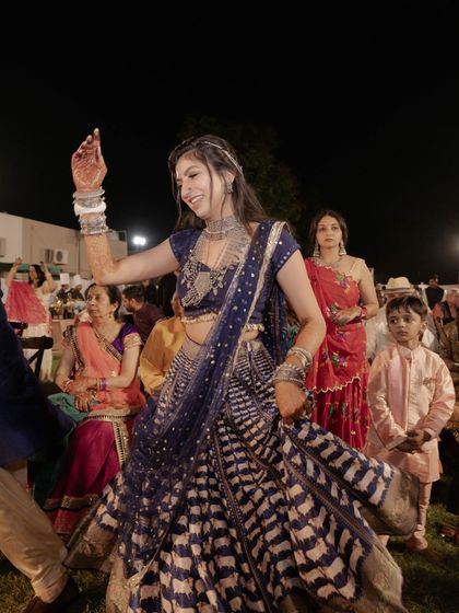 The bride twirling, her printed lehenga creating a beautiful blur of motion.