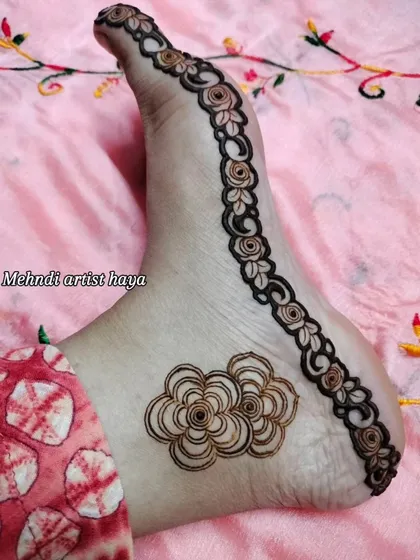 A delicate and minimalist foot design, with a simple floral vine along the side and a single flower motif. Perfect for a party or a guest.