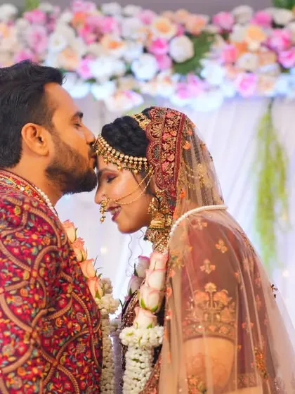 A tender forehead kiss, a timeless expression of love captured against a beautiful floral backdrop.