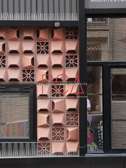 A detailed shot of the terracotta jaali pattern on the Chadha Properties office. The geometric design of the clay blocks adds a layer of traditional craftsmanship to the modern structure.