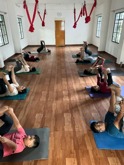 During the same Yin Yoga class, students are holding Ananda Balasana (Happy Baby Pose). This posture is excellent for releasing tension in the hips and lower back, which is a common issue from sitting for long hours.